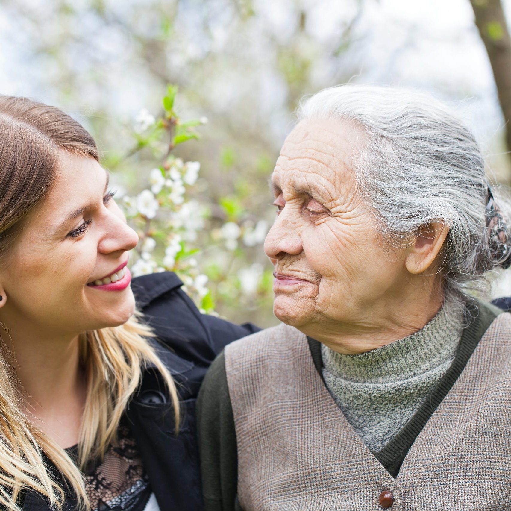 Picture of a happy elderly woman with her cheerful carer outdoor springtime